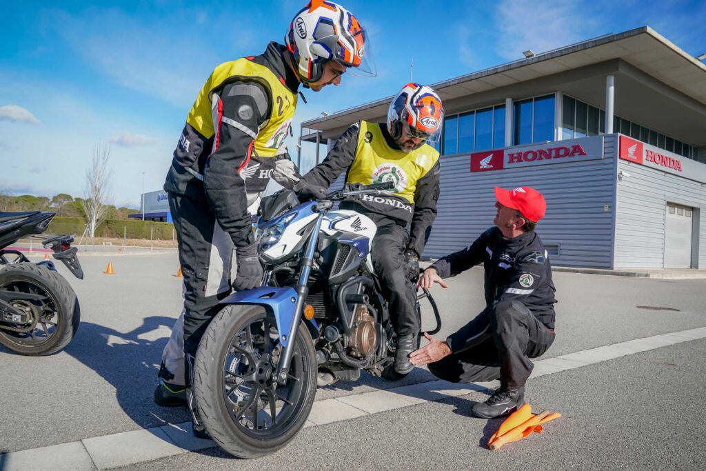 Instructor aconsejando y corrigiendo los errores de un motorista.